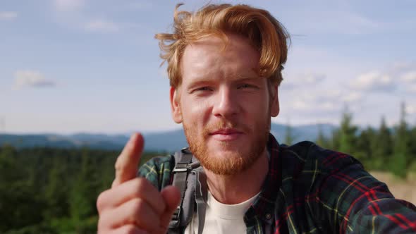 Guy Having Video Conversation in Mountains