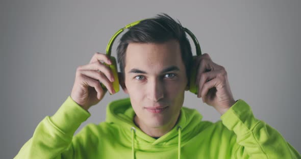 Young Male in Green Sweatshirt Listening to Music