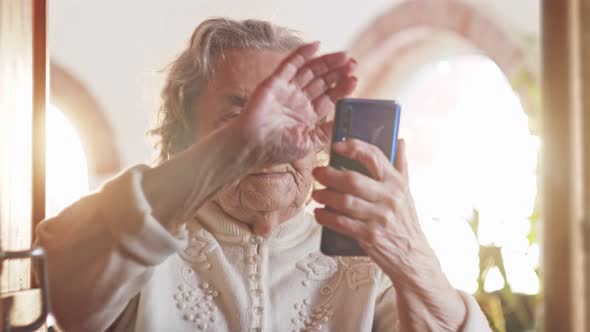 Elderly Woman Grandmother Waves Her Hand Greets on Video a Call of Her Friends or Relatives While