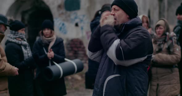 Homeless Male Immigrant Rubbing Hands In Cold During War