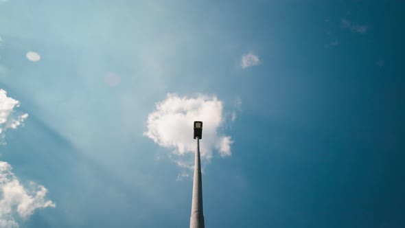 Bottom view of a blue sky with moving clouds over a streetlight, Timelpase