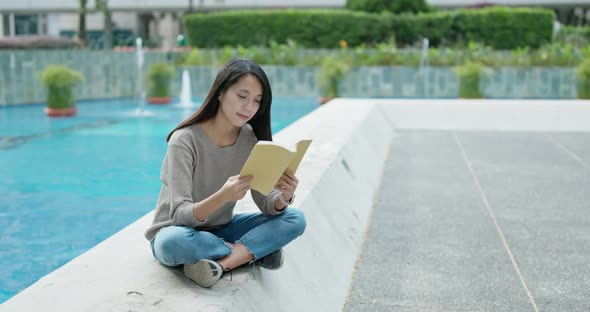 Woman read on the book and sit outside