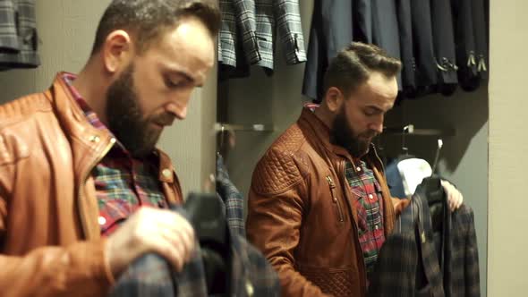 Stylish Young Man Trying On Suit In Store.