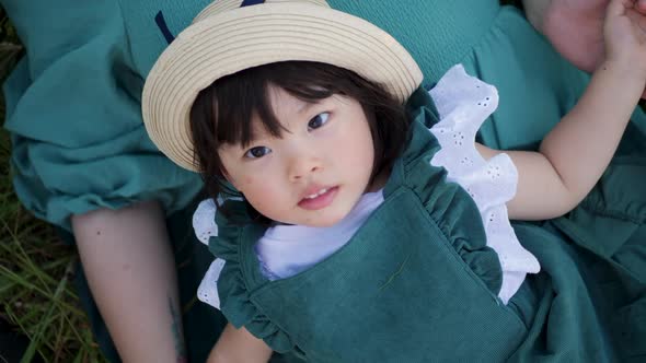 Koreans Family Mother and Daughter in Green Dresses Sitting in the Long Grass