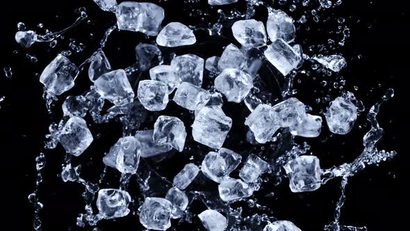 Super Slow Motion Shot of Rotating Exploded Ice Cubes and Splashing Water on Black at 1000Fps alt