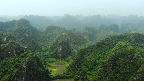 Aerial: North Vietnam karst landscape at sunset, drone view of Ninh Binh region, tourist destination