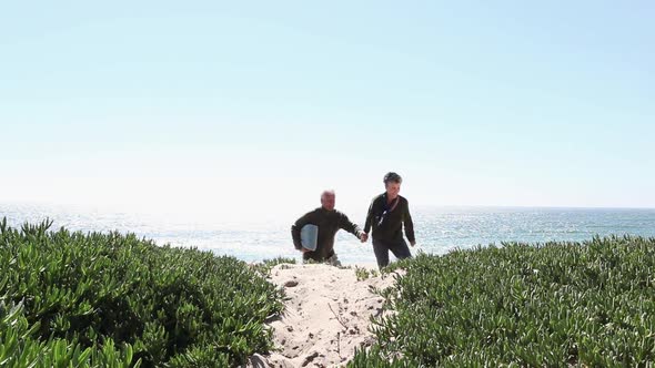 Couple walking hand in hand over sand dunes