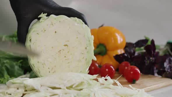 Chef Cuts the Cabbage with a Knife in Slow Motion Making a Salad Fresh Vegetables on a Cutting Board