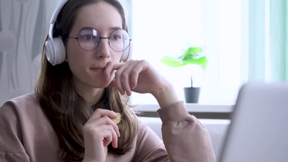 A Girl at Home Watching an Online Broadcast and Gnawing on Cookies