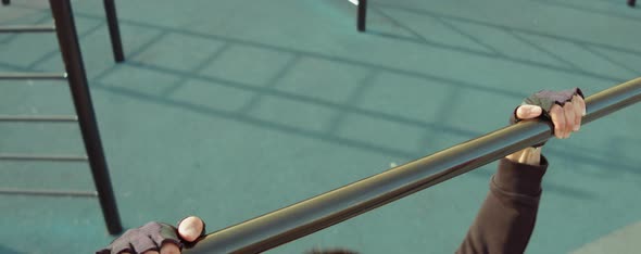 Man Exercising on Pull-Up Bar at Workout Playground