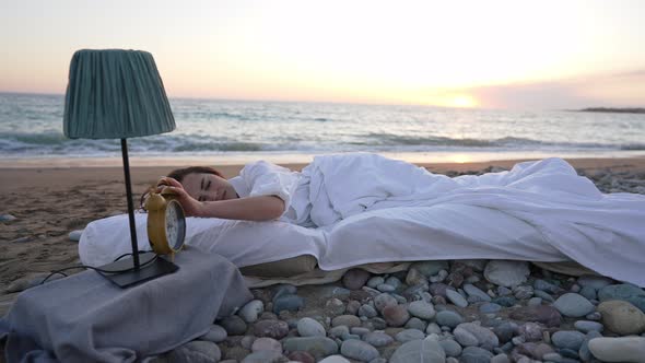 Wide Shot of Sleeping Young Woman Turning Off Alarm Dropping Clock in Slow Motion