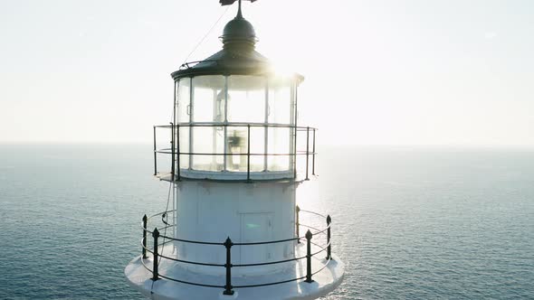 Close up lighthouse top against sunlight and sun rays.