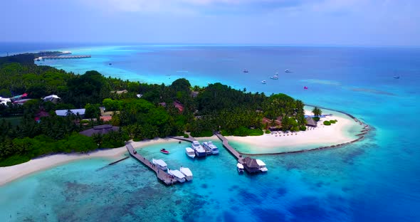 Wide aerial travel shot of a white paradise beach and blue water background in 4K