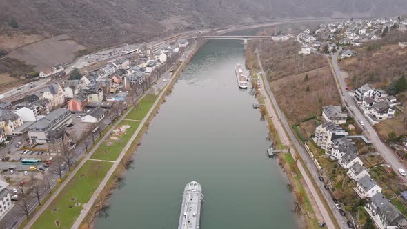 birds eye view of the valley and the mosel river with a barge passing the city of cochem in germany