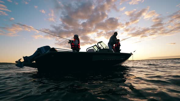 Children Are Catching Fish with Their Father While Being on a Boat