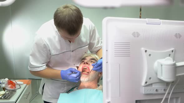 Dentist Examining Elderly Patient.