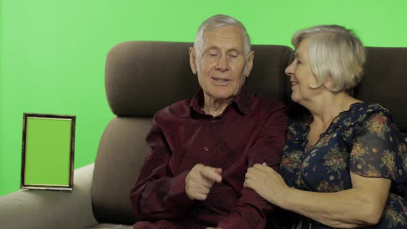 Senior Aged Man and Woman Sitting Together on a Sofa and Talking. Chroma Key