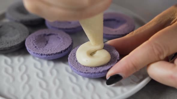 Pastry Bag Putting Cream on the Half of Macaroon