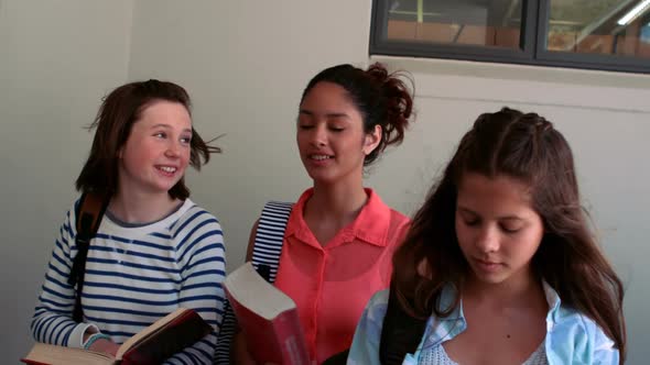 Schoolgirls interacting with each other in corridor