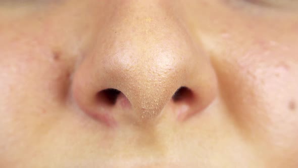 A Woman Smells with Her Nose - Closeup