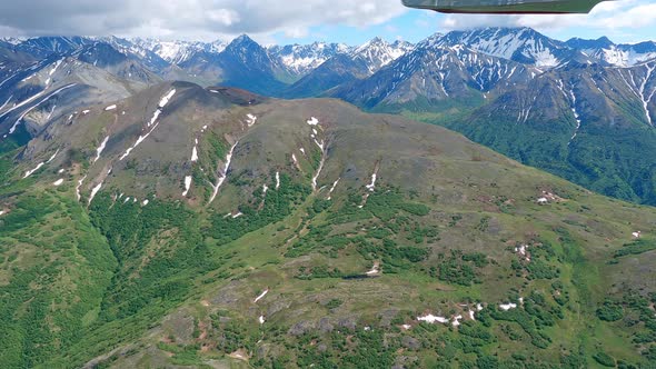 Flying along a remote alpine mountain ridge in the Talkeetna Range of Alaska, filmed from a small ai