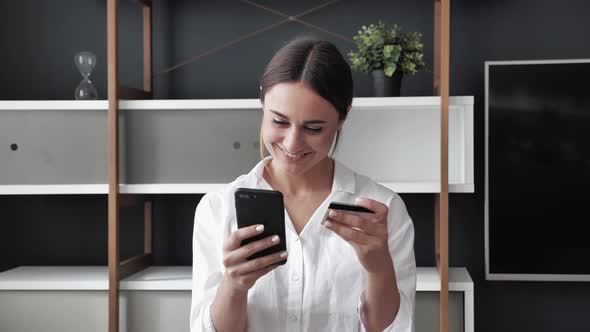 Close Up View Young Female Holding Smartphone and Credit Card a Makes Instant Distance Payment or