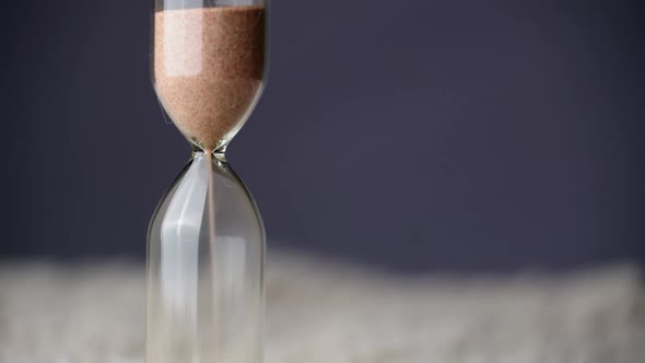 Countdown Hourglass Pouring on Purple Background