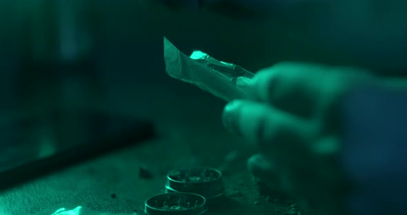 Man Rolling a Medical Marijuana Joint in Night Club