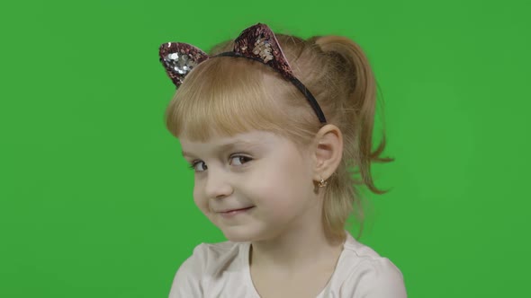 Girl in Cat Headband Winks. Happy Four Years Old Child. Chroma Key