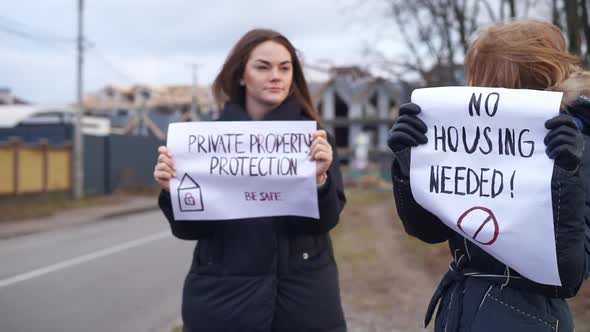 Two Caucasian Female Activists Talking Standing Outdoors with Placards