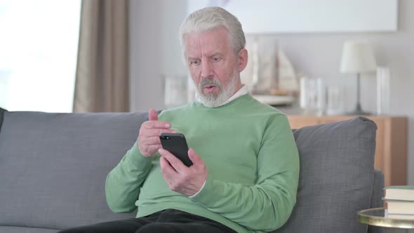 Sad Old Man Having Failure on Smartphone at Home