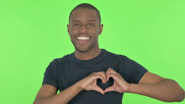 Handmade Heart By Young African Man on Green Background