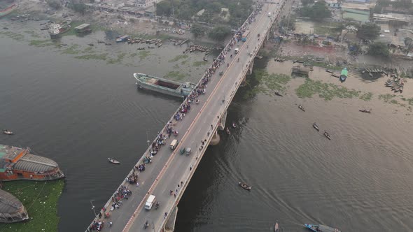 Aerial view of traffic on a bridge at Old Dhaka steamer ghat with cars and ships crossing along Buri