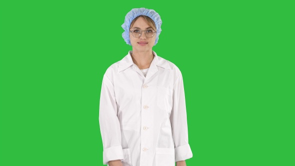 Nice Blonde Woman Doctor Walking on a Green Screen, Chroma Key.