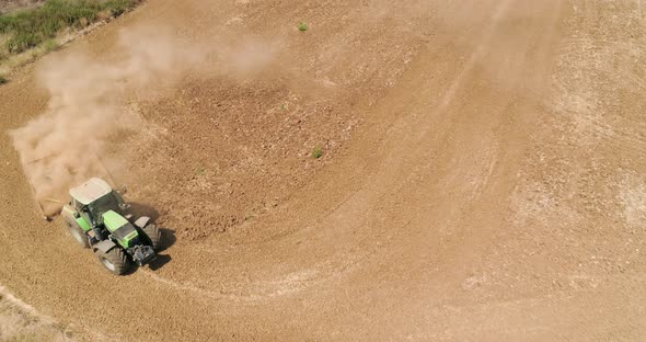 Aerial view of a tractor ploughing an empty field, Kibbutz saar, Israel.