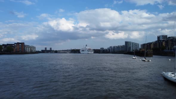 Drone shot flying low over River Thames with boat and ship in London