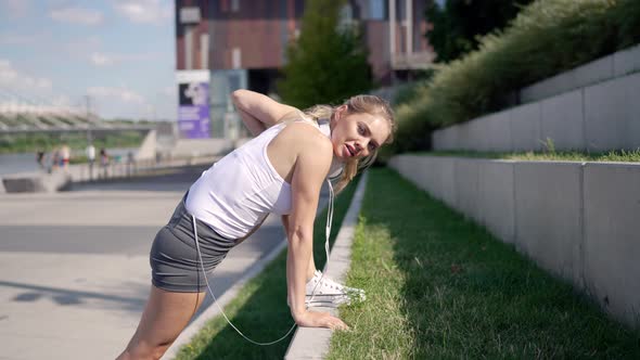 Sportswoman Lunging Near Grassy Steps