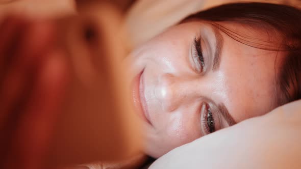 Pleasant Woman Using Smartphone While Resting in Bed