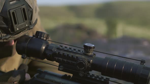 Hands of a Man Sniper in Protective Green Gloves Adjust the Sight of a Sniper Rifle