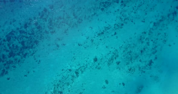 Daytime aerial copy space shot of a white paradise beach and aqua blue ocean background in colorful 