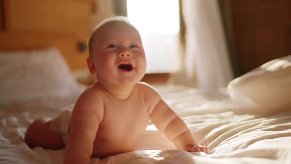 Beautiful Smiling Baby Gorgeous Little Baby Lie on Bed and Smile at Camera with Nice Soft Focus