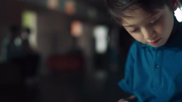 Closeup Schoolboy Using Tablet Surfing Internet in Hall