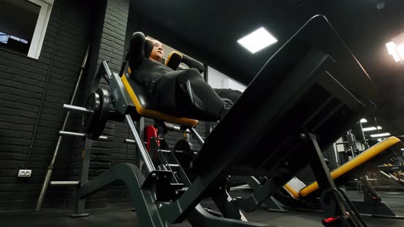 Athletic Man Performs Exercises with a Barbell in Gym