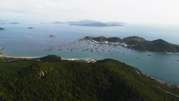 Aerial view of Binh hung island with many anchored boats in bay with epic mountain landscape and oce