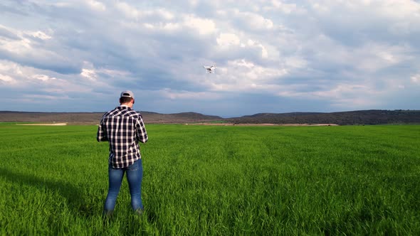 Young Farmer Flying a Drone Over a Field