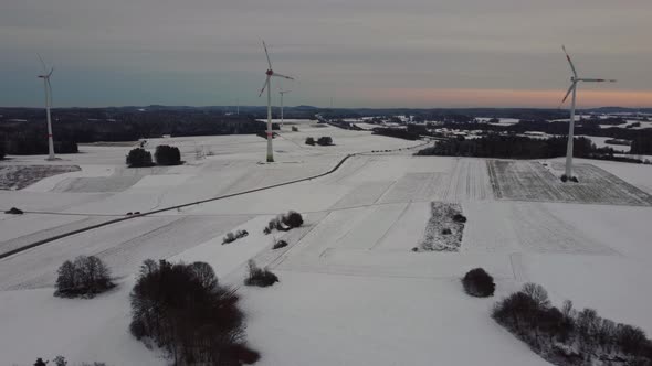 Aerial view of a wind farm in winter. Aerial view of rotating wind turbines.