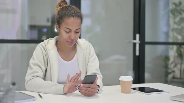 Attractive African Woman Using Smartphone in Office