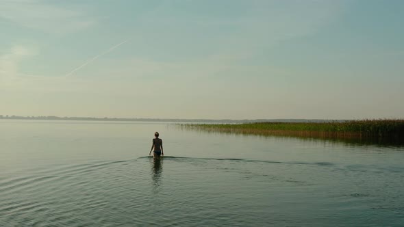 Aerial Drone View, Attractive Young Woman Walking in a Lake at Summer Day. V2