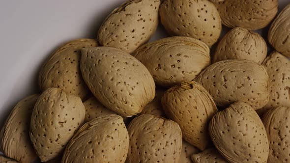 Cinematic, rotating shot of almonds on a white surface - ALMONDS