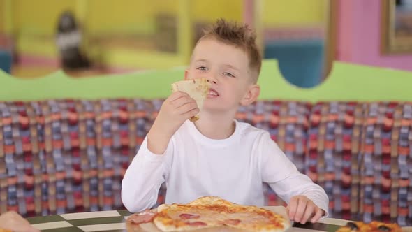 Little boy eats delicious pizza. Italian pizza